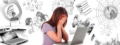 woman using laptop with face in hands, drawings of all her roles on wall behind her